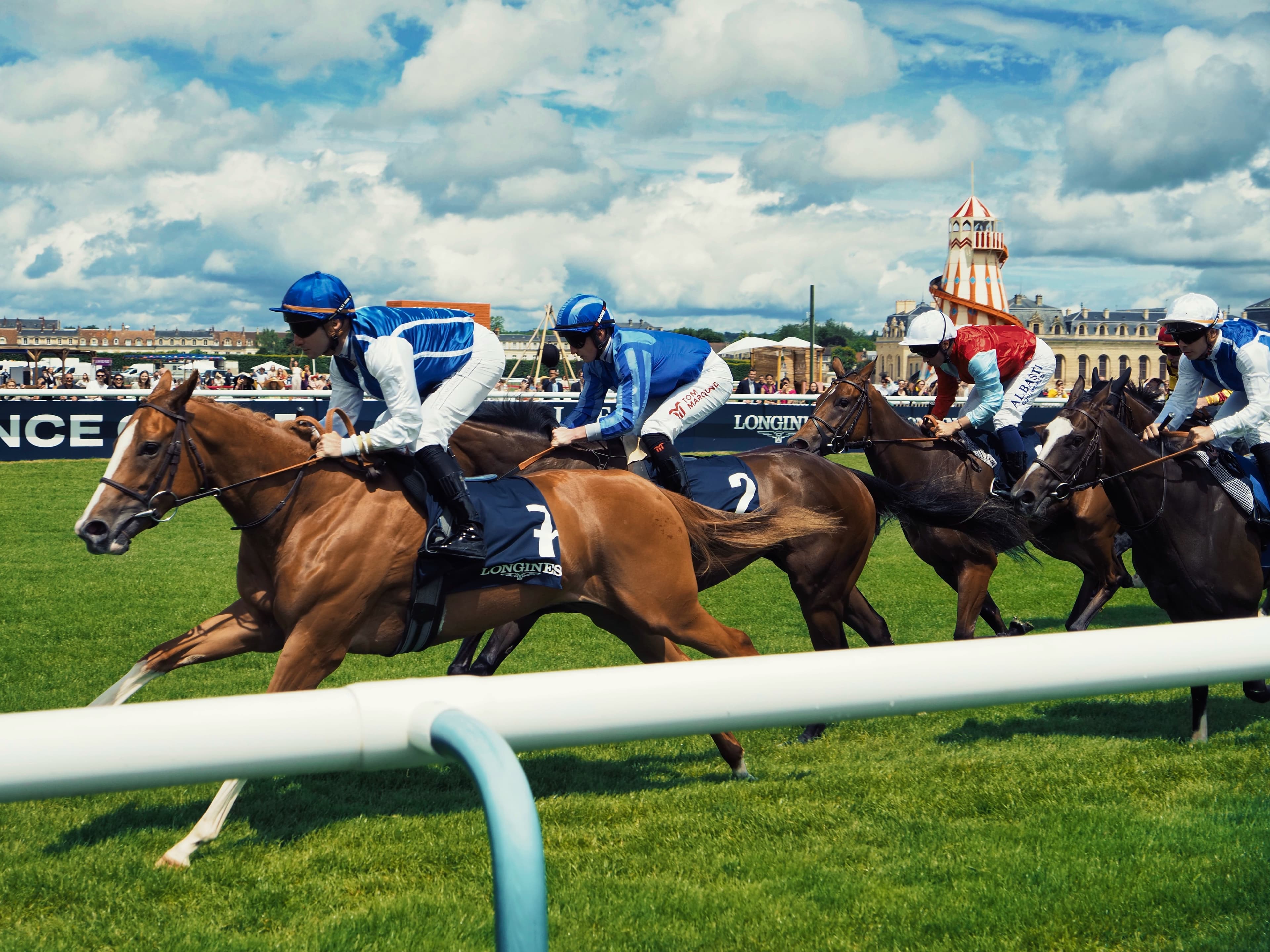 Tribunes blanches de l'hippodrome de Chantilly et chapeaux dans la foule un dimanche de juin